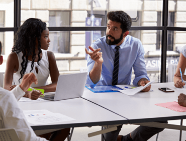 collaborateurs discutant autour d'une table lors d'une réunion