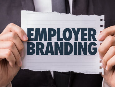 Mann mit Schild Employer Branding in der Hand