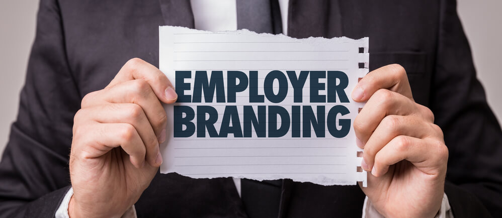 Mann mit Schild Employer Branding in der Hand